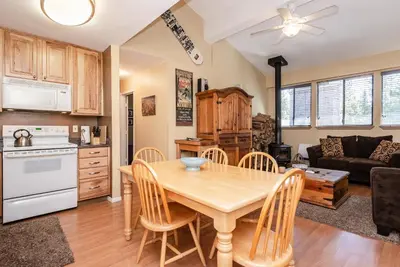 a kitchen and living room with a wooden table and chairs at Summit B- # 257 in Mammoth Lakes