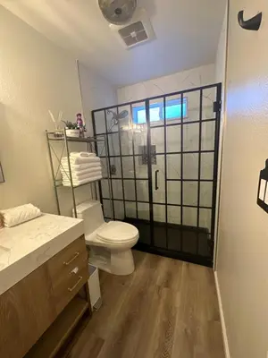 a bathroom with a toilet and a glass shower door at YoBee! Park Reservation Included! Heart of Yosemite - Homey Studios and Breakfast in Yosemite West