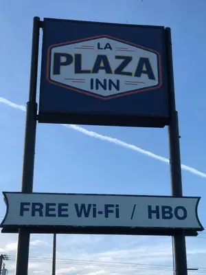 a sign for a pizza inn with a free wii fit sign at La Plaza Inn in Los Banos