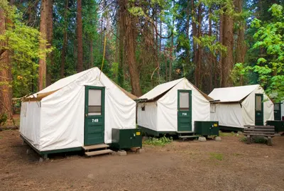 a group of three tents in a forest at Curry Village in Curry Village