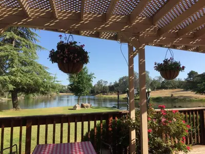 a wooden pergola with a view of a river at Oak Retreat by Yosemite National Park in Coarsegold