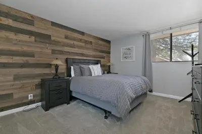 a bedroom with a wooden accent wall and a bed at San Sierra 2 in Mammoth Lakes