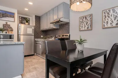 a kitchen with a black table and chairs and a refrigerator at San Sierra 2 in Mammoth Lakes