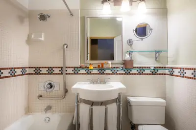 a bathroom with a sink and a toilet and a mirror at The Ahwahnee in Yosemite Village
