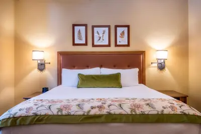 a bedroom with a large bed with two lamps at The Ahwahnee in Yosemite Village