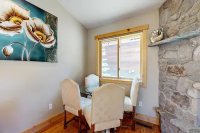 a dining room with a table and chairs and a stone wall at Sweet Cherry Hills Escape in South Lake Tahoe