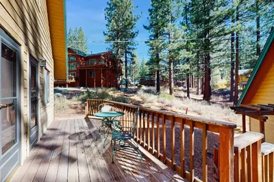 a wooden porch with a table on the side of a house at Tallac Views Getaway in South Lake Tahoe