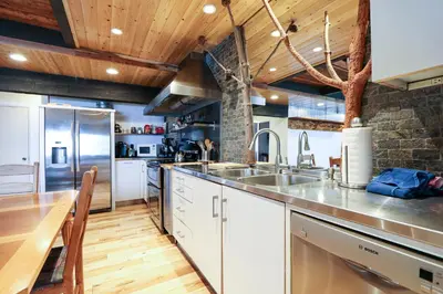a kitchen with white cabinets and a wooden table at Bigwood #80 condo in Mammoth Lakes