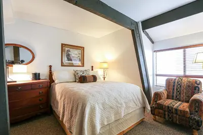 a bedroom with a bed and a dresser and a window at Bigwood #80 condo in Mammoth Lakes