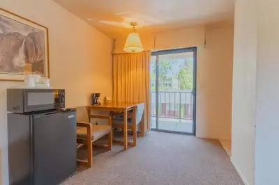 a room with a kitchen and a table with a microwave at Mariposa Lodge in Mariposa