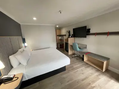 a hotel room with a large bed and a desk at The Midtowner Hotel, SureStay Collection by Best Western in Sacramento
