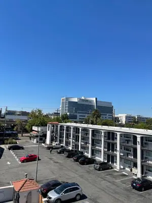 a parking lot with cars parked in front of a building at The Midtowner Hotel, SureStay Collection by Best Western in Sacramento
