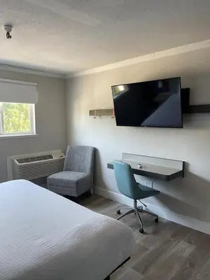 a hotel room with a bed and a desk and a tv at The Midtowner Hotel, SureStay Collection by Best Western in Sacramento