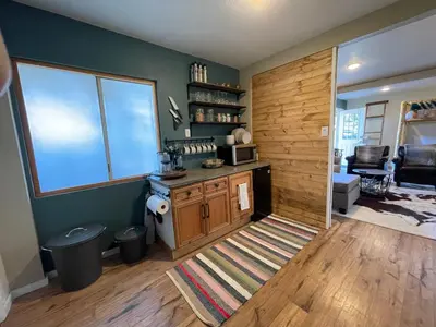 a room with a kitchen with a wooden wall at Yosemite Basecamp in Groveland