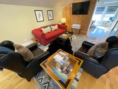 a living room with couches and a red couch at Yosemite Basecamp in Groveland