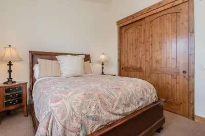 a bedroom with a large bed and a wooden door at Creekhouse 1312 in Mammoth Lakes