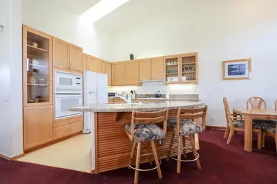 a kitchen with wooden cabinets and a table with chairs at Snowcreek V #999 condo in Mammoth Lakes