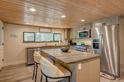 a kitchen with a stainless steel refrigerator and a wooden ceiling at Relaxation on Muletail in Carnelian Bay