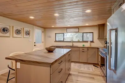 a kitchen with a wooden ceiling and a large island at Relaxation on Muletail in Carnelian Bay