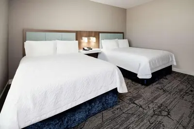 two beds in a hotel room with white sheets at Hampton Inn & Suites Gilroy, Ca in Gilroy