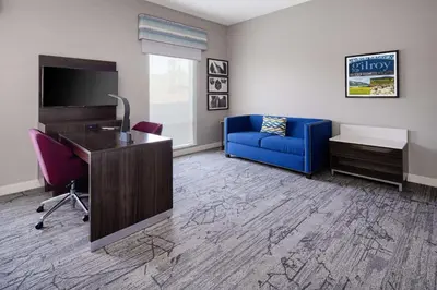 an office with a blue chair and a desk and a tv at Hampton Inn & Suites Gilroy, Ca in Gilroy