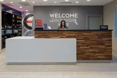 a woman standing behind a counter in a store at Hampton Inn & Suites Gilroy, Ca in Gilroy