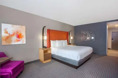 a hotel room with a bed and a couch at La Quinta by Wyndham Madera in Madera