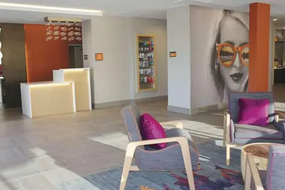 a room with chairs and a painting of a woman at La Quinta by Wyndham Madera in Madera