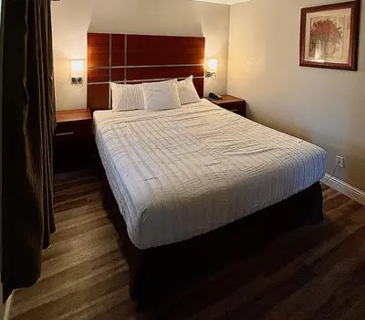 a hotel room with a large bed and two night stands at Western Holiday Lodge in Three Rivers