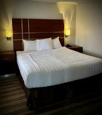 a bedroom with a large bed with a wooden headboard at Western Holiday Lodge in Three Rivers