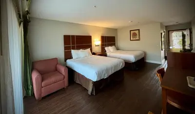 a hotel room with two beds and a chair at Western Holiday Lodge in Three Rivers