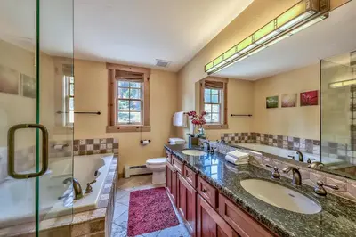 a bathroom with two sinks and a shower and a tub at Three-Bedroom Townhouse in Kirkwood