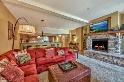 a living room with a red couch and a fireplace at Three-Bedroom Townhouse in Kirkwood