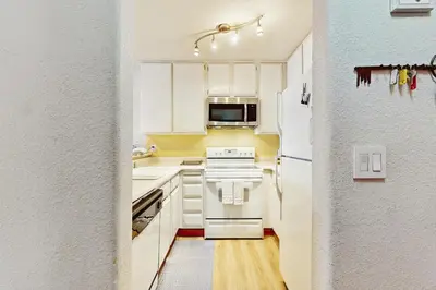 a kitchen with white cabinets and a white refrigerator at Scott Peak Views in Alpine Meadows