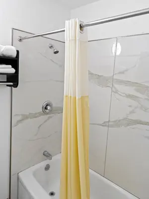 a bathroom with a shower with a yellow shower curtain at Dream Inn in Fresno
