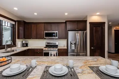a kitchen with wooden cabinets and a marble counter top at Mountainside 15 in Mammoth Lakes