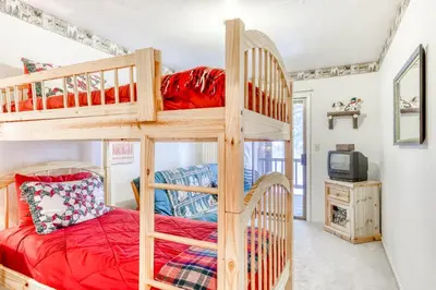 a bedroom with bunk beds and a tv in a room at Northstar Condo in the Trees in Truckee
