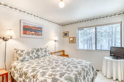 a bedroom with a bed and a tv and a window at Northstar Condo in the Trees in Truckee