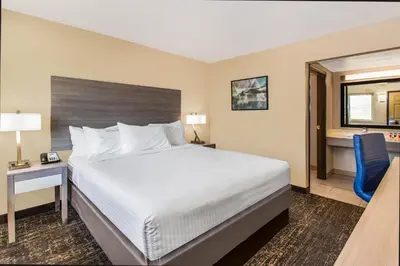 a hotel room with a bed and a desk and a chair at Days Inn Merced / Yosemite Area in Merced