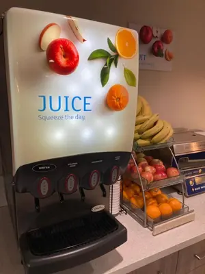 a juicer sitting on a counter with fruits and vegetables at Days Inn Merced / Yosemite Area in Merced