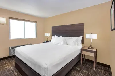 a hotel room with a large bed and two windows at Days Inn Merced / Yosemite Area in Merced