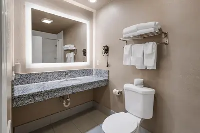 a bathroom with a toilet and a sink and a mirror at Heritage Inn - Yosemite/Sonora in Sonora