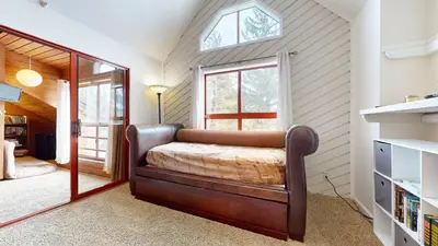 a bedroom with a bed and a window and a mirror at Aspen Creek #311 condo in Mammoth Lakes