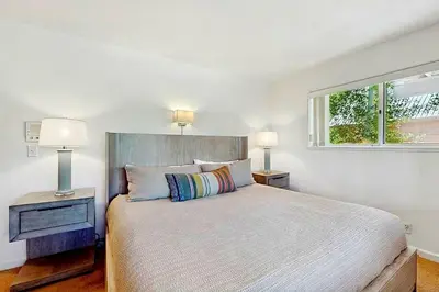 a bedroom with a bed with two lamps and a window at Sleek Hill Haven with Martis Valley Views in Polaris