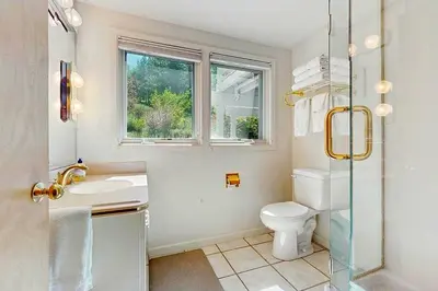 a bathroom with a toilet and a sink and a window at Sleek Hill Haven with Martis Valley Views in Polaris