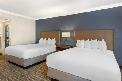 two beds in a hotel room with white sheets at Best Western Town & Country Lodge in Tulare