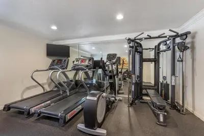a gym with treadmills and machines in a room at Best Western Town & Country Lodge in Tulare