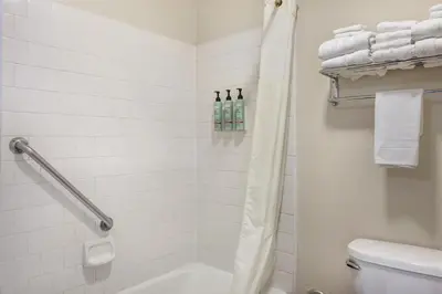 a bathroom with a shower and a toilet and towels at Best Western Town & Country Lodge in Tulare