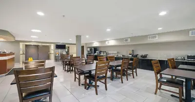 a dining room with tables and chairs in a restaurant at SureStay Plus Hotel by Best Western Rocklin in Rocklin