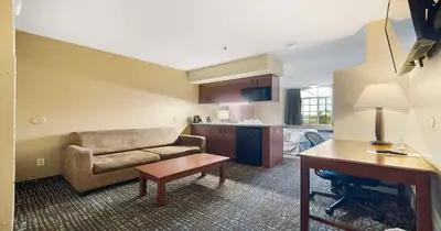 a living room with a couch and a table at SureStay Plus Hotel by Best Western Rocklin in Rocklin
